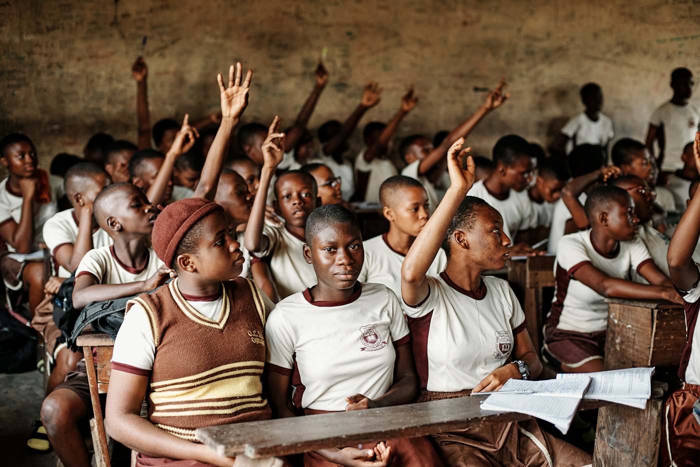 Pupils with their hands up in class